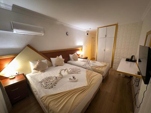a hotel room with two beds and a television at Far Life Hotel in Antalya
