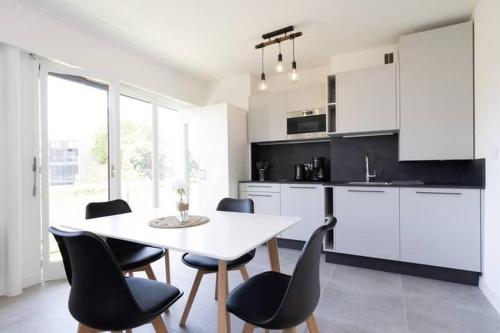 a kitchen with a white table and black chairs at Studio Cap Antibes in Juan-les-Pins