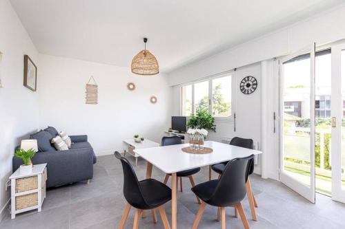 a white living room with a table and chairs at Studio Cap Antibes in Juan-les-Pins