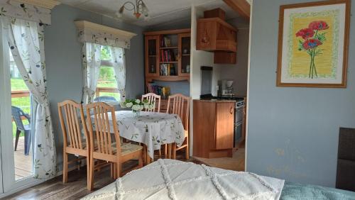 - une cuisine et une salle à manger avec une table et des chaises dans l'établissement Ranczo Tomaszówka Domek w Polu, 