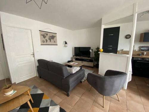 un salon avec un canapé et une chaise dans l'établissement Appartement Centre ville, à Granville