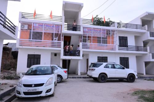 two cars parked in front of a building at Jankivihar Homestay at Prahladghat within 1km from Shri Ram Mandir in Ayodhya