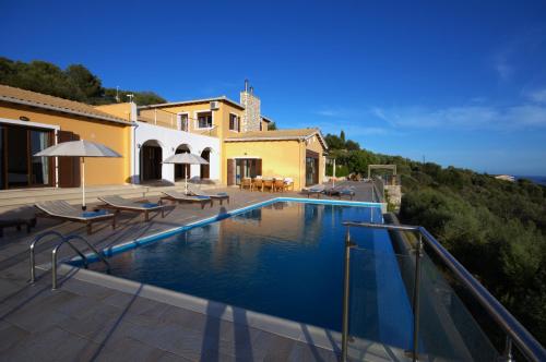 a swimming pool in front of a house at Adamas Villa in Sivota