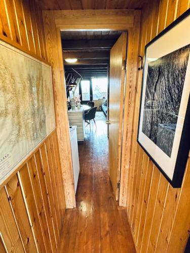 a hallway leading to a living room with wood paneling at Cozy Cabin in Stunning Nature - Borgarfjordur in Staðarhús