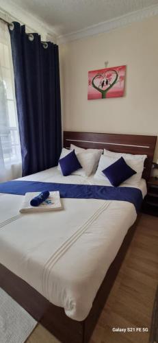 a bedroom with two beds with blue and white pillows at Crystal Cribs Eldoret in Eldoret