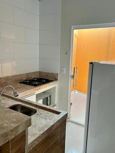 a kitchen with a sink and a refrigerator at Chalé Travosa in Santo Amaro