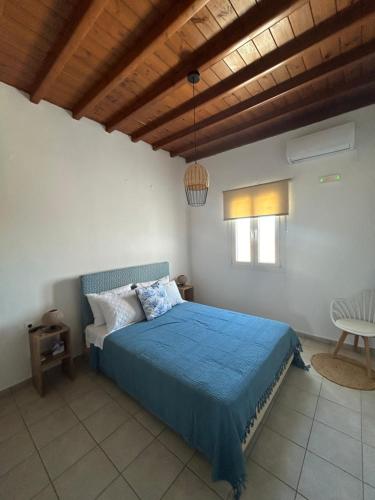 a bedroom with a bed with a blue comforter at Agyra House in Super Paradise Beach