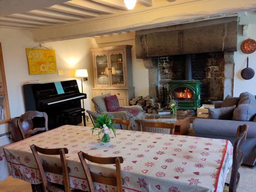un salon avec une table et une cheminée dans l'établissement Chez Marie Roulotte, à Pontfarcy
