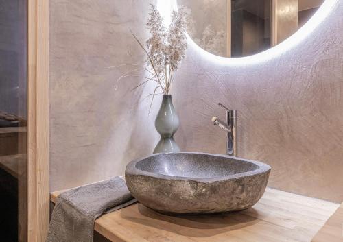 a bathroom with a large stone sink and a vase at Villa David in Espoo