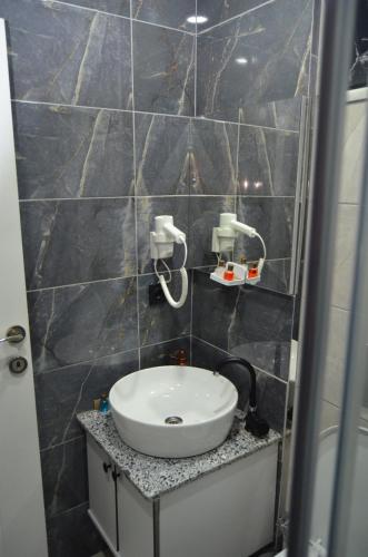 a bathroom with a sink in a tiled wall at BENİM EV in Akçatepe