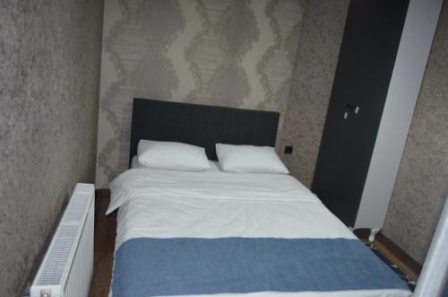 a bedroom with a bed with white sheets and pillows at BENİM EV in Akçatepe