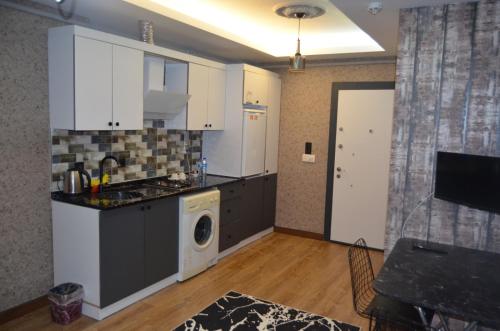 a kitchen with white cabinets and a washer and dryer at BENİM EV in Akçatepe