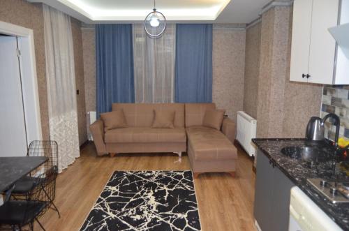 a living room with a couch and a kitchen at BENİM EV in Akçatepe