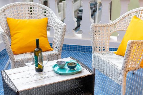 a table with a bottle of wine and two chairs at La Casa di Bianca in Follonica