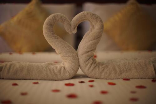 two towels shaped like hearts are on a table at Rajah Park Hotel by Hiverooms in Cebu City