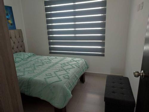 a bedroom with a bed and a window with blinds at Casa confort nueva Cerca de outlets y Hospital Regional in Santa Gertrudis