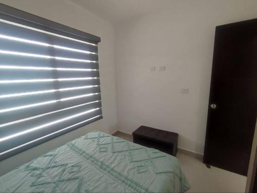 a bedroom with a bed and a window with blinds at Casa confort nueva Cerca de outlets y Hospital Regional in Santa Gertrudis