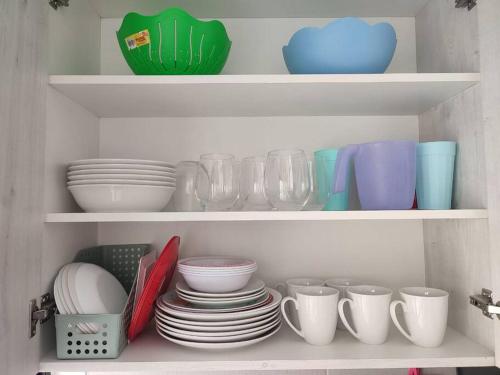 a cabinet filled with plates and cups and bowls at Casa confort nueva Cerca de outlets y Hospital Regional in Santa Gertrudis