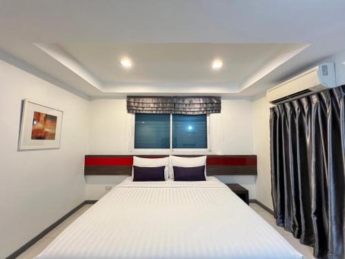 a bedroom with two beds and a window at Cubic Pratunam in Bangkok