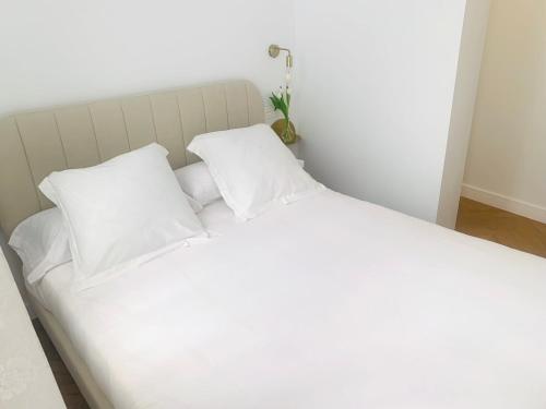 uma cama branca com duas almofadas brancas em Casa del Azucar em Motril