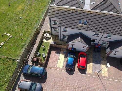 a group of cars parked in a parking lot next to a building at Normsy Place Seaside Serenity Breath Taking Views in St Bees