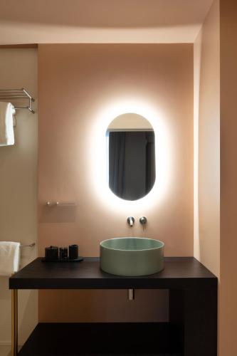 a bathroom with a green sink and a mirror at Interno Marche Design Experience Hotel in Tolentino