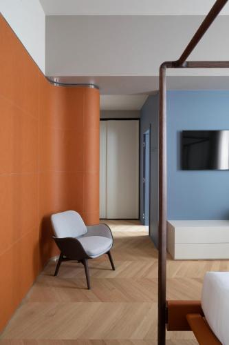 a room with a chair and a wall at Interno Marche Design Experience Hotel in Tolentino
