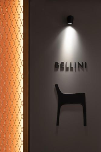 a black chair in front of a wall with a sign at Interno Marche Design Experience Hotel in Tolentino