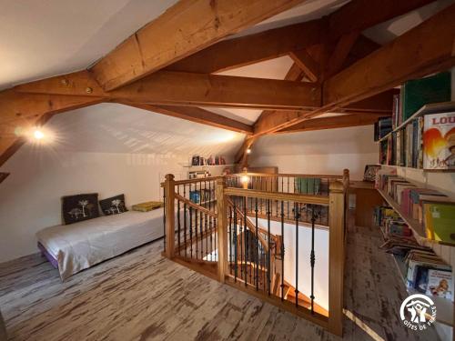 Cette chambre mansardée comprend un lit et une étagère. dans l'établissement Chez Aurore, à La Sauvetat