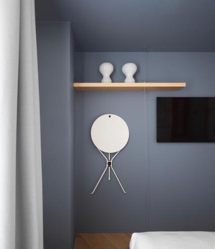 a bedroom with a blue wall with a mirror on a shelf at Interno Marche Design Experience Hotel in Tolentino