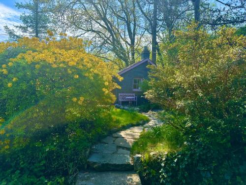 una piccola casa in mezzo a un giardino di Cosy Country Cottage in Eryri Snowdonia with Hot Tub near Cardigan Bay a Llanbedr