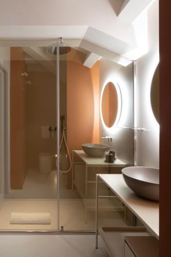 a bathroom with two sinks and a glass shower at Interno Marche Design Experience Hotel in Tolentino