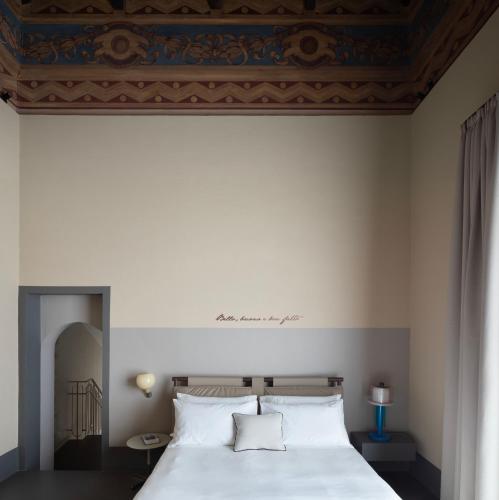 a bedroom with a white bed with a blue ceiling at Interno Marche Design Experience Hotel in Tolentino