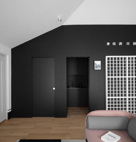 a living room with a couch and a black wall at Interno Marche Design Experience Hotel in Tolentino