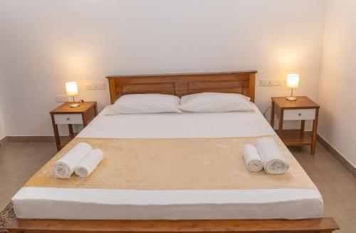 1 dormitorio con 1 cama grande y 2 mesitas de noche en Villa Verde Alawwa, en Alawwa