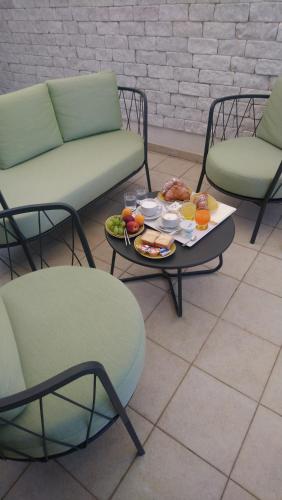 een tafel met een dienblad met eten en twee stoelen bij Al Corso Charming Rooms in Peschici