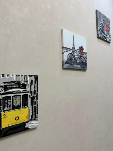 a painting of a bus and a picture of a bike on a wall at Luxury two-room apartment with beautiful mountain views in Almaty