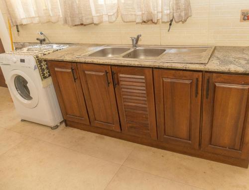 a kitchen with a sink and a washing machine at Villa Verde Alawwa in Alawwa