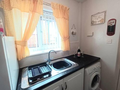 a kitchen with a sink and a washing machine at Bungalow in Shildon County Durham in Shildon