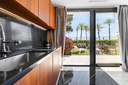 a kitchen with a sink and a view of a patio at Puerto Banús Beach Apartments in Marbella