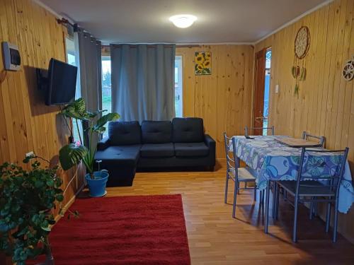 ein Wohnzimmer mit einem Tisch und einem Sofa in der Unterkunft Cabañas Lomas de Putagan in Linares