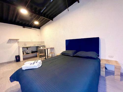 um quarto com uma grande cama azul num quarto em Súper Apartamento central en Casa Colonial Bogotá em Bogotá