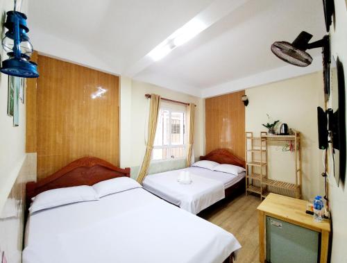 a hotel room with two beds and a window at Bình Đào Hotel - Khách sạn ngay trung tâm giá rẻ in Da Lat