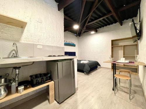 a kitchen and living room with a bed in the background at Súper Apartamento central en Casa Colonial Bogotá in Bogotá