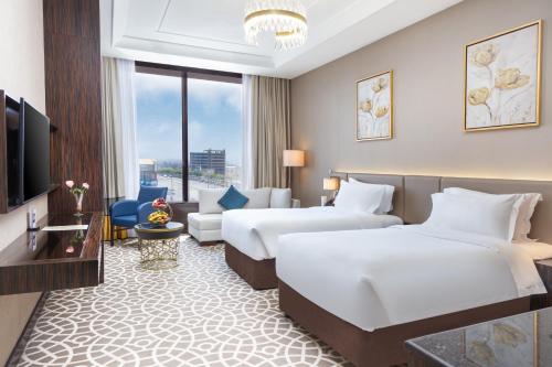 um quarto de hotel com duas camas e uma televisão em Nivel Hotel em Khamis Mushayt