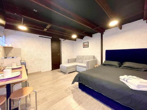 a bedroom with a bed and a table and a chair at Súper Apartamento central en Casa Colonial Bogotá in Bogotá