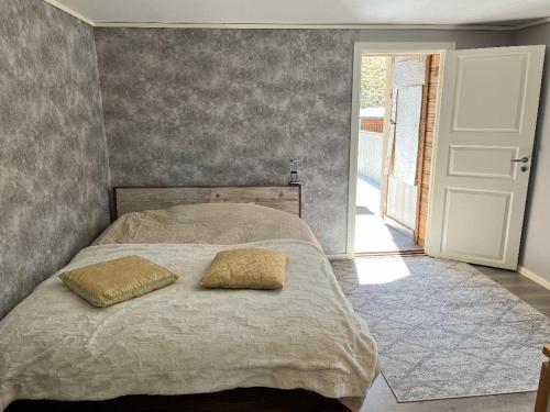 1 dormitorio con 1 cama con 2 almohadas en The Fisher's cabin en Stjoerdal