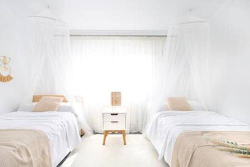 a bedroom with two beds and a window at Apartamento con Piscina Ribadumia in Ribadumia