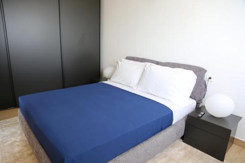 a bedroom with a bed with a blue comforter at Heliconia Park Lagos Luxury Apartments in Lagos