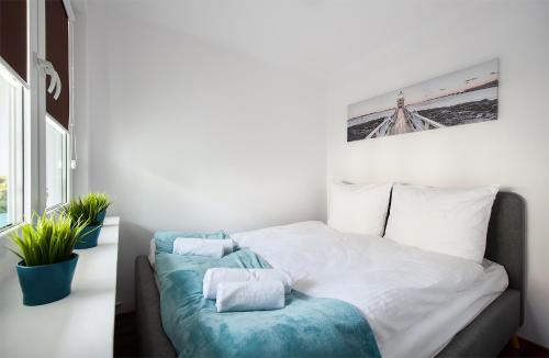 a bedroom with a bed with blue and white sheets at Apartament 1 blisko Atlas Areny, ZOO oraz Orientarium in Łódź
